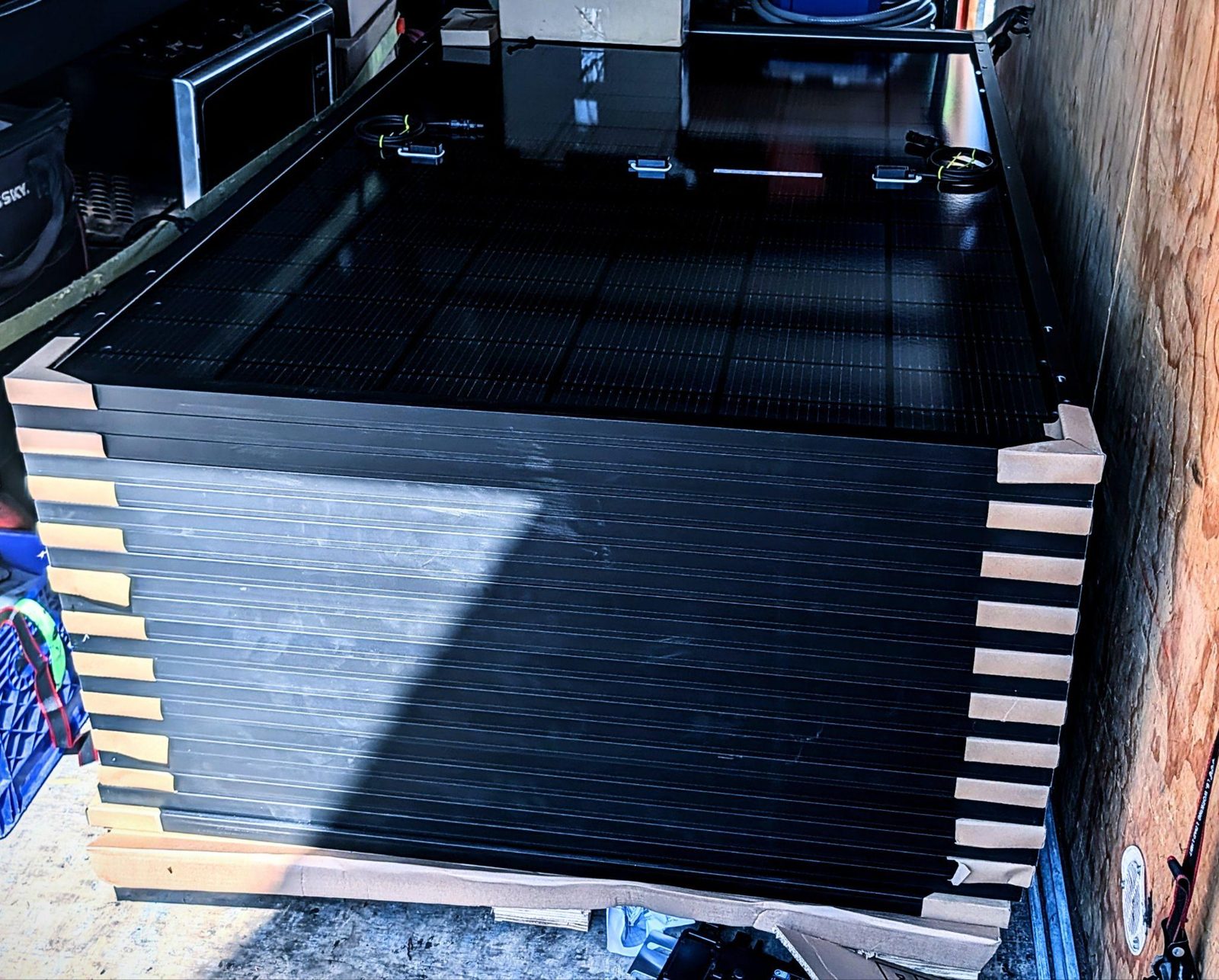 A pallet of all-black solar panels ready for installation